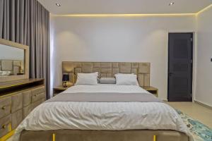 Un dormitorio con una cama grande y un espejo. en Yomsdale Air B N B, en Lekki
