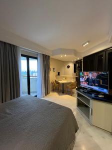 a bedroom with a bed and a flat screen tv at Hotel Sena Madureira Ibirapuera Com Garagem 1210 in Sao Paulo