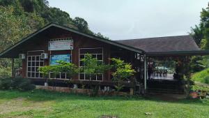 ein kleines Gebäude mit einem Schild am Fenster in der Unterkunft Mahua Lodge and Campsite in Tambunan