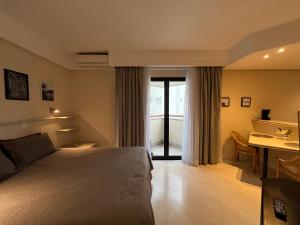 a bedroom with a bed and a desk and a table at Hotel Sena Madureira Ibirapuera Com Garagem 1210 in Sao Paulo +30 photos