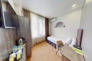 a hotel room with a bed and a tv at Median Hotel, City Center Yerevan in Yerevan