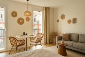 a living room with a couch and a table and chairs at L'épure - Clim - Confort - Moderne in Lourdes