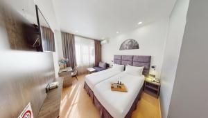 a hotel room with a bed with a tray on it at Median Hotel, City Center Yerevan in Yerevan