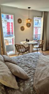 a bedroom with a bed and a table and chairs at L'épure - Clim - Confort - Moderne in Lourdes
