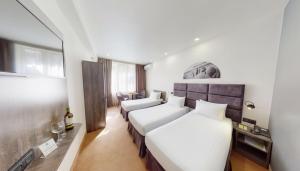 a hotel room with two beds and a couch at Median Hotel, City Center Yerevan in Yerevan