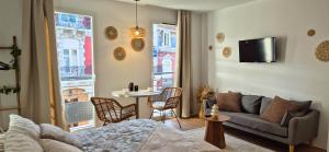 a living room with a couch and a table at L'épure - Clim - Confort - Moderne in Lourdes