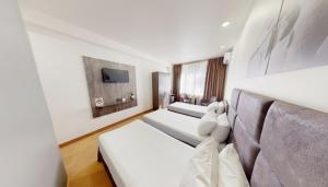 a hotel room with two beds and a tv at Median Hotel, City Center Yerevan in Yerevan