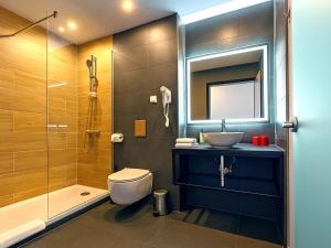 a bathroom with a sink and a toilet and a shower at DORMERO Hotel Weimar in Weimar +14 photos