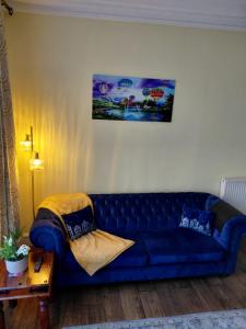 a blue couch sitting in a living room at Alastrean Flat in Aberdeen