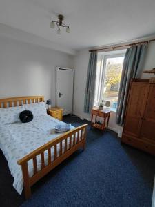 a bedroom with a bed and a large window at Alastrean Flat in Aberdeen