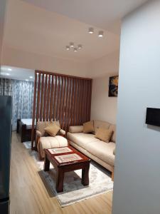 a living room with a couch and a coffee table at Deluxe Queen Studio with swimming pool in Nairobi, Himalaya Heights Apartment, Kilimani in Nairobi