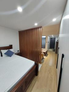a bedroom with a large bed with a wooden wall at Deluxe Queen Studio with swimming pool in Nairobi, Himalaya Heights Apartment, Kilimani in Nairobi