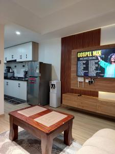 a kitchen with a table and a tv in a room at Deluxe Queen Studio with swimming pool in Nairobi, Himalaya Heights Apartment, Kilimani in Nairobi