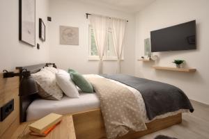 ein Schlafzimmer mit einem Bett und einem Flachbildfernseher in der Unterkunft Stunning seaview Villa Katharina in Šarić