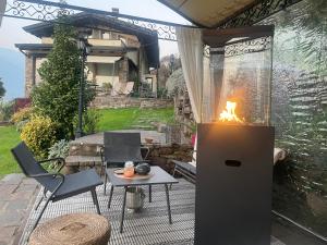 a fireplace on a patio with a table and chairs at Casa Ronco Frati, piscina vista lago in Pisogne