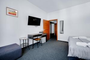 um quarto com duas camas e uma escrivaninha com televisão em 7Days B&B em Bratislava