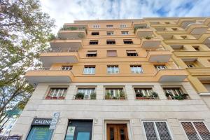 a tall yellow building with windows and plants at Foro Italico Guesthouse in Rome