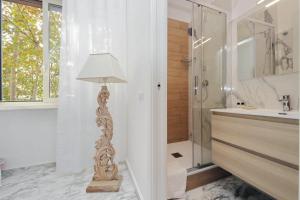 a bathroom with a shower and a floor lamp at Foro Italico Guesthouse in Rome +49 photos