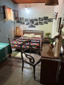 a bedroom with a bed and a table and a chair at Vila Caribé in Lençóis +24 photos