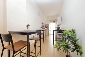 a dining room with black tables and chairs and plants at Foro Italico Guesthouse in Rome