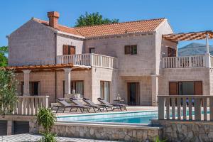 a house with a swimming pool in front of it at Midnight Serenity in Čilipi