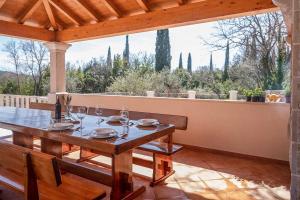 un tavolo in legno con bicchieri da vino su un patio di Midnight Serenity a Čilipi