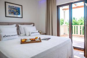 un letto bianco con un vassoio di cibo sopra di Midnight Serenity a Čilipi Altre 36 foto