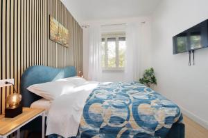 a bedroom with a bed with a blue chair and a desk at Foro Italico Guesthouse in Rome