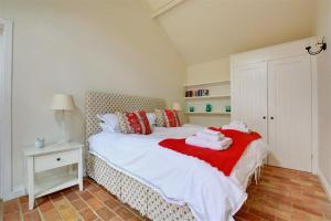 ein Schlafzimmer mit einem Bett mit Handtüchern darauf in der Unterkunft Simons Barn in Langham