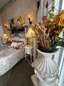 a bedroom with a bed and a vase with flowers in it at Spend this night in Venice whilst visiting Swansea in Swansea +7 photos