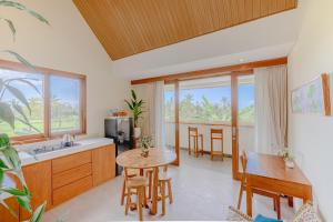 a kitchen and dining room with a table and chairs at The Vinaya Boutique Hotel in Ubud