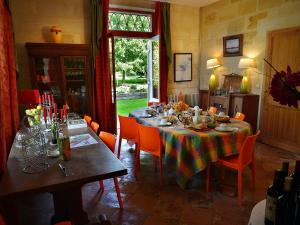 a dining room with a table with orange chairs at Petit Garros in Fronsac +18 photos