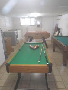 a room with a pool table and two tables at Gîte familial avec salle de jeux in Charency-Vezin