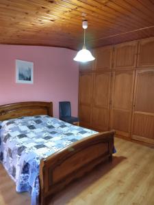 a bedroom with a bed in a room with wooden cabinets at Gîte familial avec salle de jeux in Charency-Vezin
