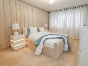 a white bedroom with a bed and two night stands at Mellings Place in Carnforth