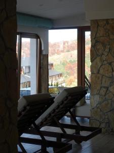 Zwei Stühle stehen auf einem Balkon vor einem Fenster in der Unterkunft Peak Montana Kopaonik in Kopaonik + 243 Fotos