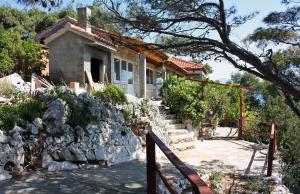 a house on a hill with a stone wall at Apartments by the sea Cove Saplunara, Mljet - 4914 in Saplunara