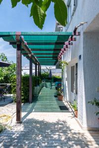 a patio with a green awning on a building at Apartments by the sea Punat, Krk - 5351 in Punat