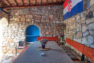 a stone walled patio with a table and a bench at Apartments and rooms by the sea Tisno, Murter - 5128 in Tisno