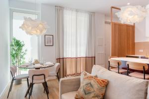 a living room with a couch and a table with chairs at Arroyo 3 Apartments in Seville