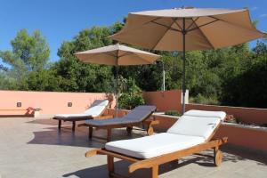 three lounge chairs and an umbrella on a patio at Family friendly apartments with a swimming pool Smokvica, Korcula - 9161 in Smokvica