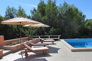 a pool with chairs and an umbrella next to a swimming pool at Family-friendly apartments with swimming pool Smokvica, Korcula - 9161 in Smokvica