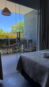 a bedroom with a bed and a large glass window at Pousada Pé na Areia in São Miguel dos Milagres