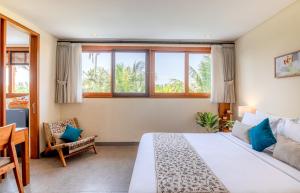 a bedroom with a bed and a desk and windows at The Vinaya Boutique Hotel in Ubud +127 photos