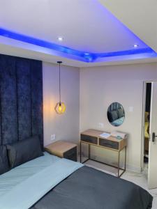a bedroom with a bed and a desk with a blue light at Modern Beachfront Escape in La Mercy in La Mercy