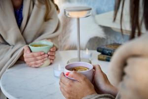 two people sitting at a table with cups of coffee at Icce Borbirtok - Wine, Dine & Rest in Monoszló
