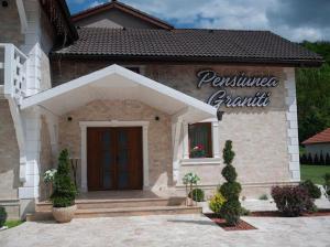 Un edificio con un letrero que dice "Familia Péndulo". en Pensiunea Graniti, en Lunca