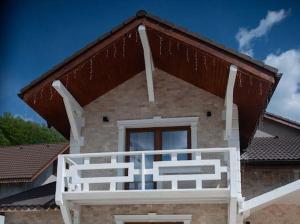 a house with a white balcony on top of it at Pensiunea Graniti in Lunca