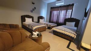a living room with two beds and a couch at Airport Gateway Guesthouse in Rawalpindi