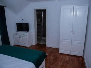 a bedroom with a bed and a television on a dresser at Pensiunea Graniti in Lunca +2 photos
